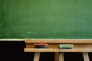 Green chalkboard with erasers on wooden stand