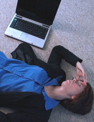 Frustrated woman on the floor next to laptop